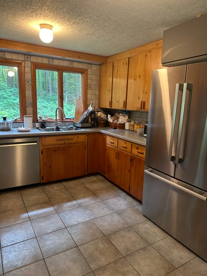 Existing kitchen in Hollis, NH, by Blackdog Design/Build/Remodel featuring natural wood cabinetry, tile flooring, stainless steel range, and laminate countertops prior to renovation.