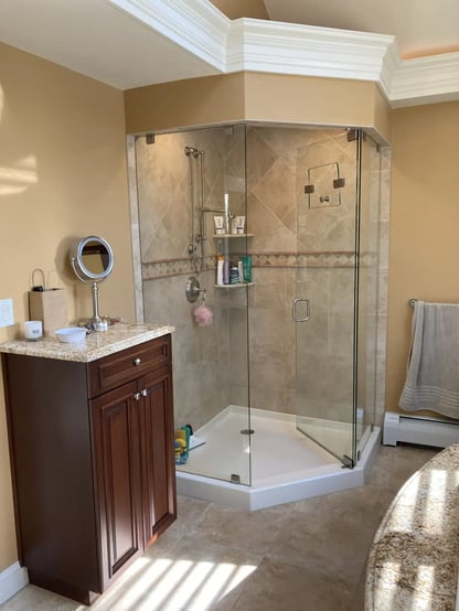 Tan-tiled standing shower with the door open