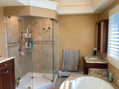 Tan-tiled standing shower with the door open