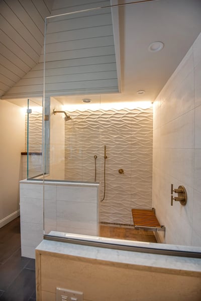 walk in, glassed in shower with bench and gold features 