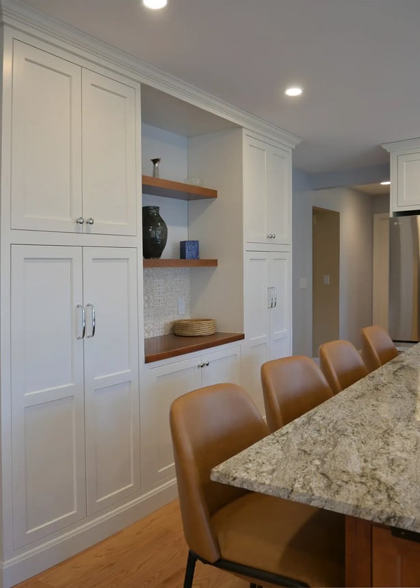 Tan leather seats at bar with white built ins