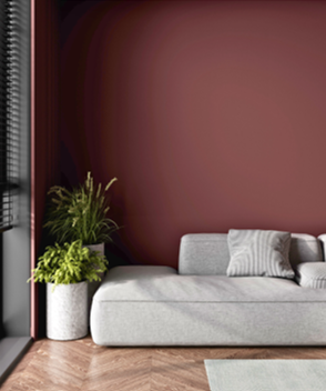 Remodeled contemporary living space with light herringbone style wood floors, large window to the left, white daybed against the wall, and far wall painted in BEHR's Rumors color.