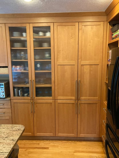 Floor to ceiling honey-toned wood cabinets in an Andover, MA home before a kitchen remodel was completed by Blackdog Design/Build/Remodel
