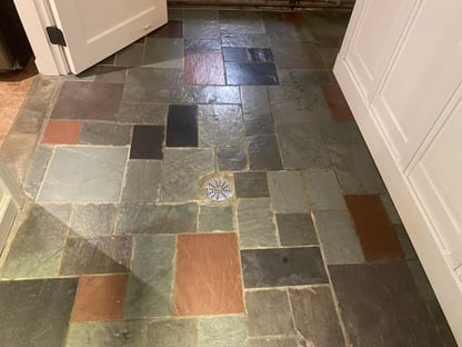 gray and rust tile flooring with drain