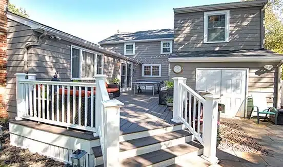 Gray house with large exterior back deck addition and string lights