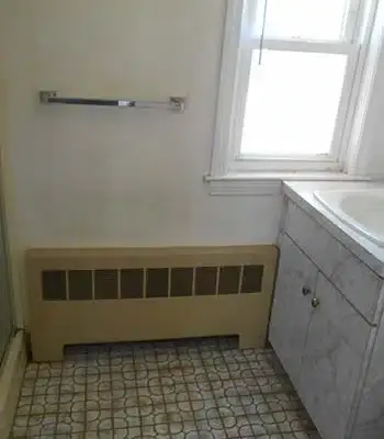 vintage home with dark hardwood and an archway leading to the kitchen