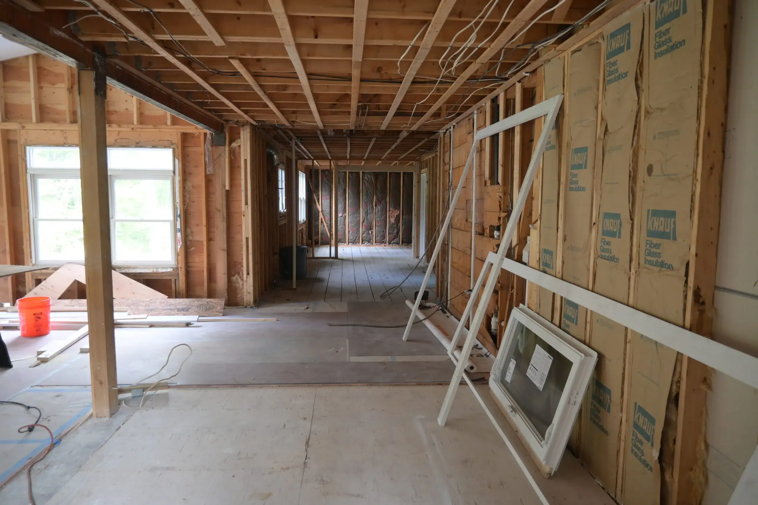 Unfinished house with bare walls and wood cutting machine in the middle