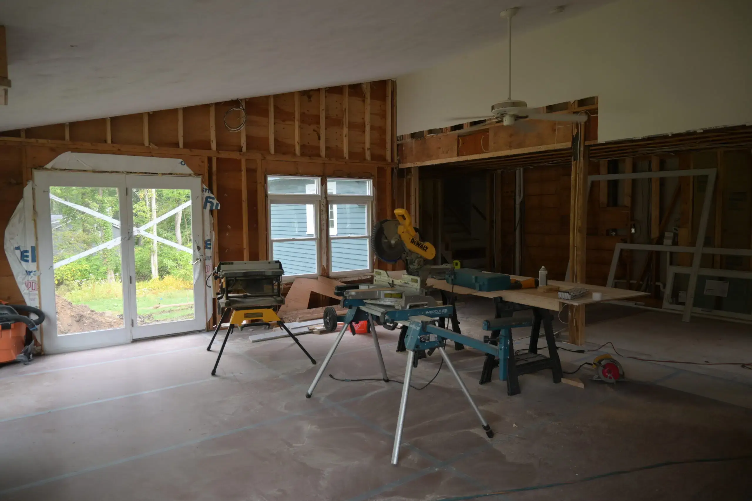 Unfinished house with bare walls and wood cutting machine in the middle
