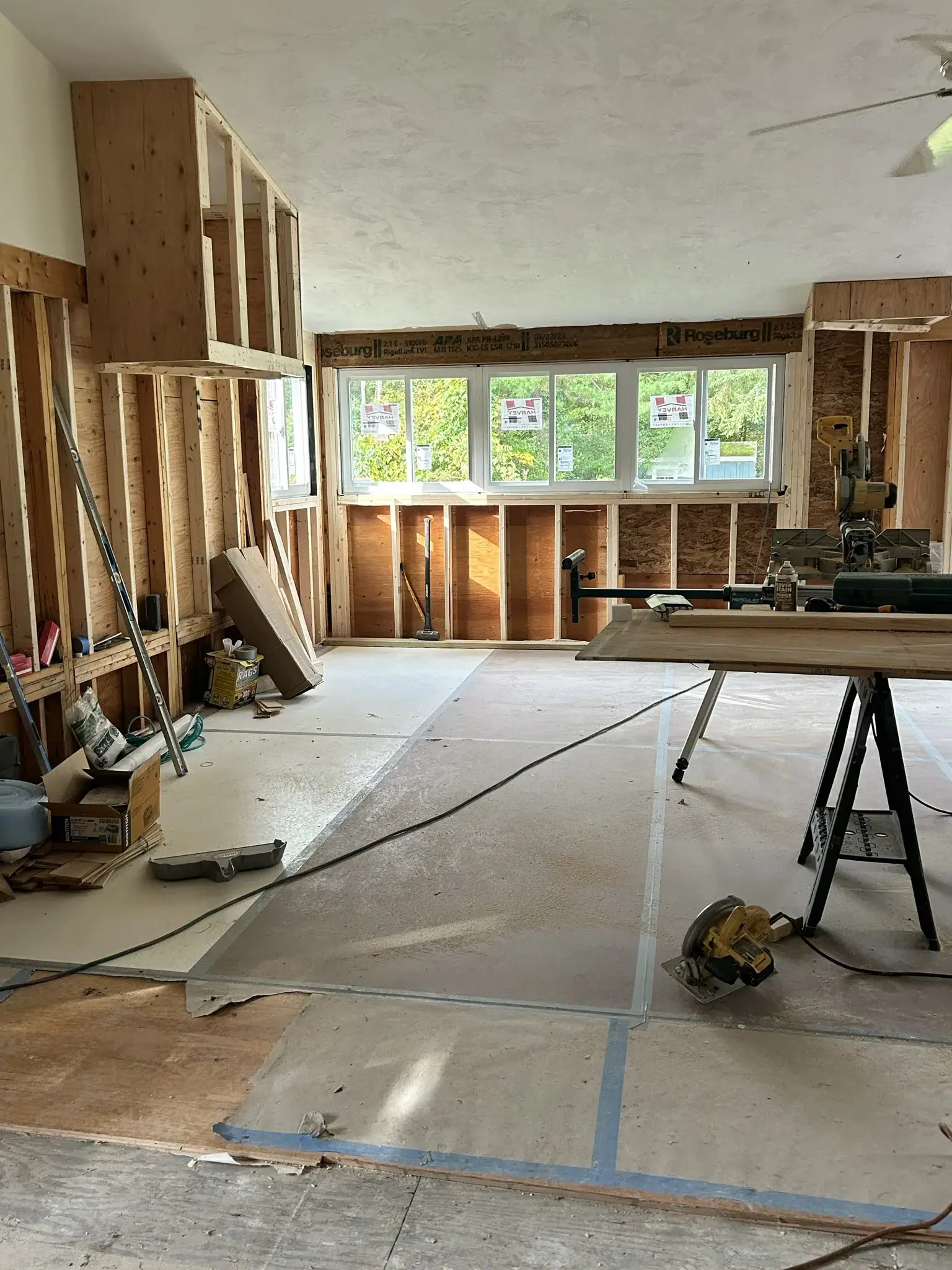 Unfinished house with bare walls and wood cutting machine in the middle