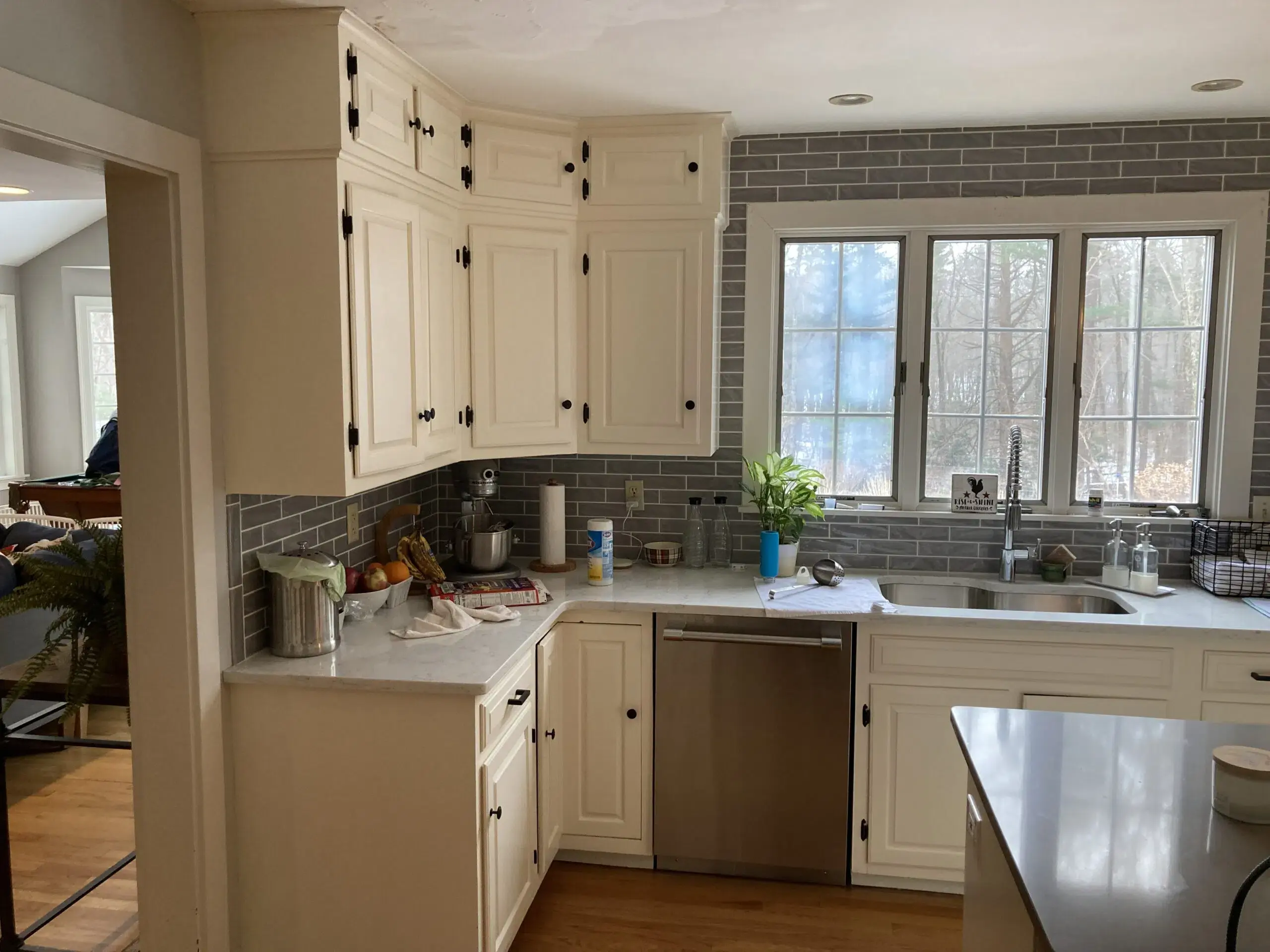 Kitchen with white cabinets, black door knobs, and white marble countertops
