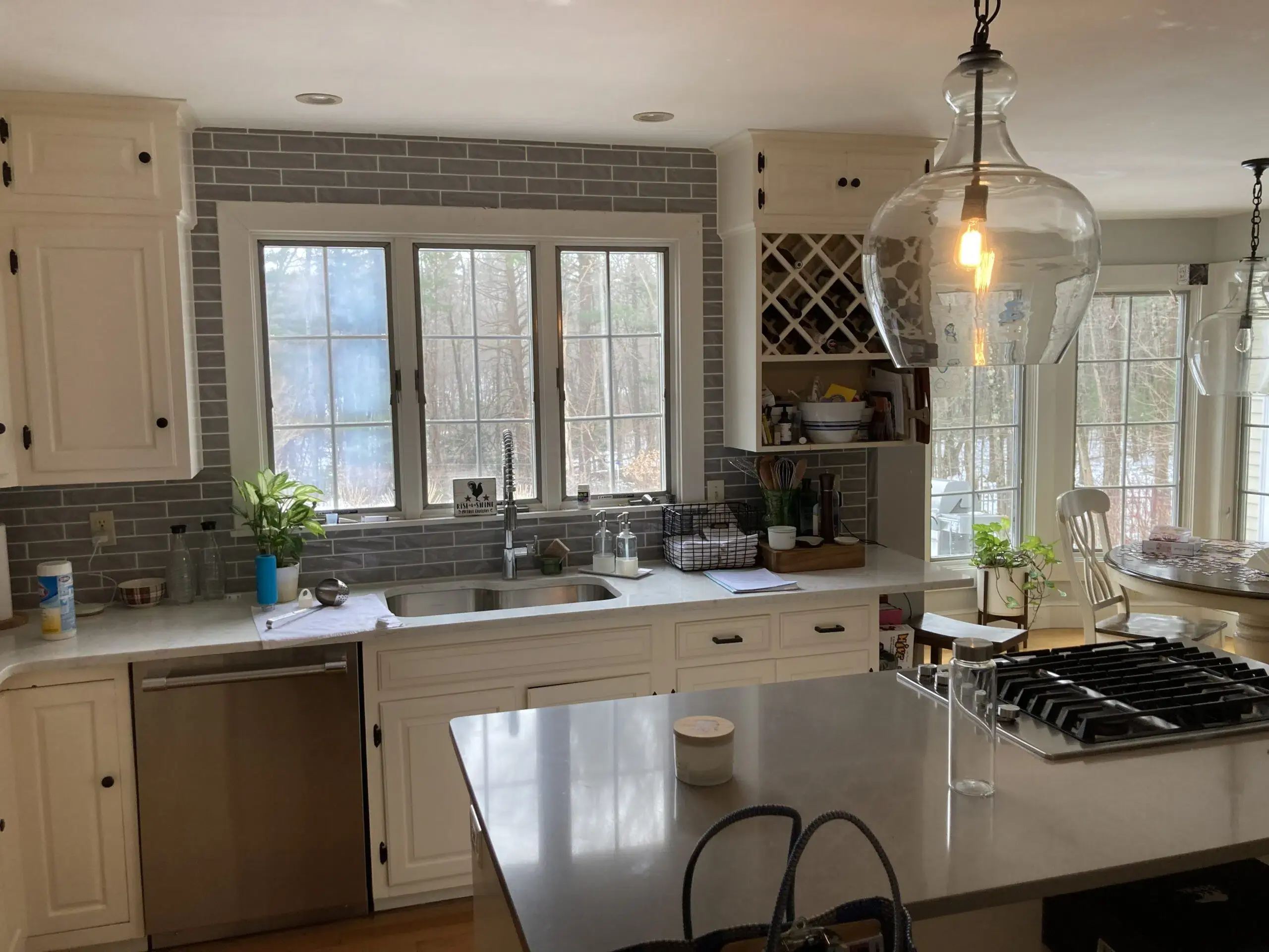 Kitchen with white cabinets, black door knobs, and white marble countertops