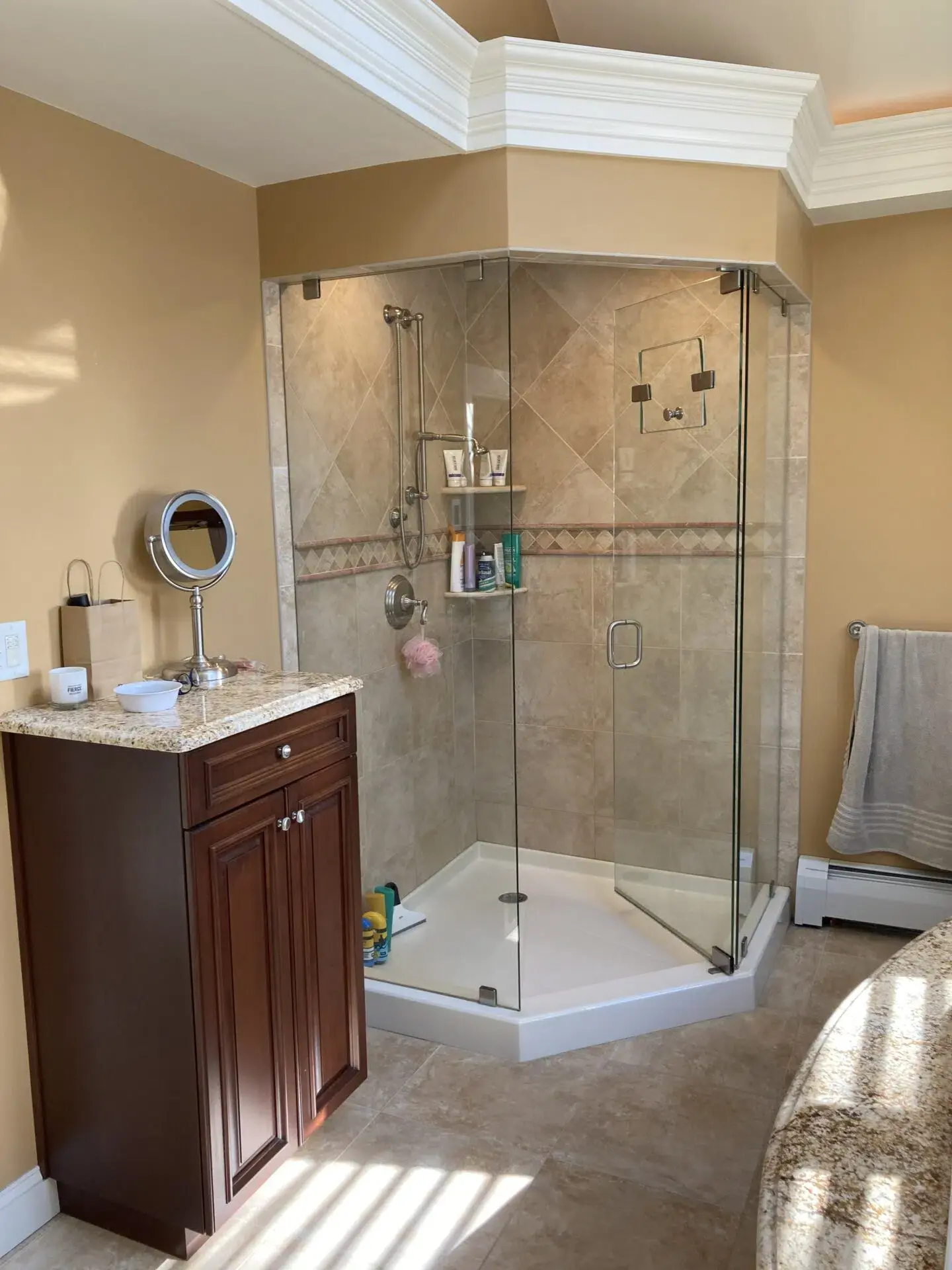 Tan-tiled standing shower with the door open