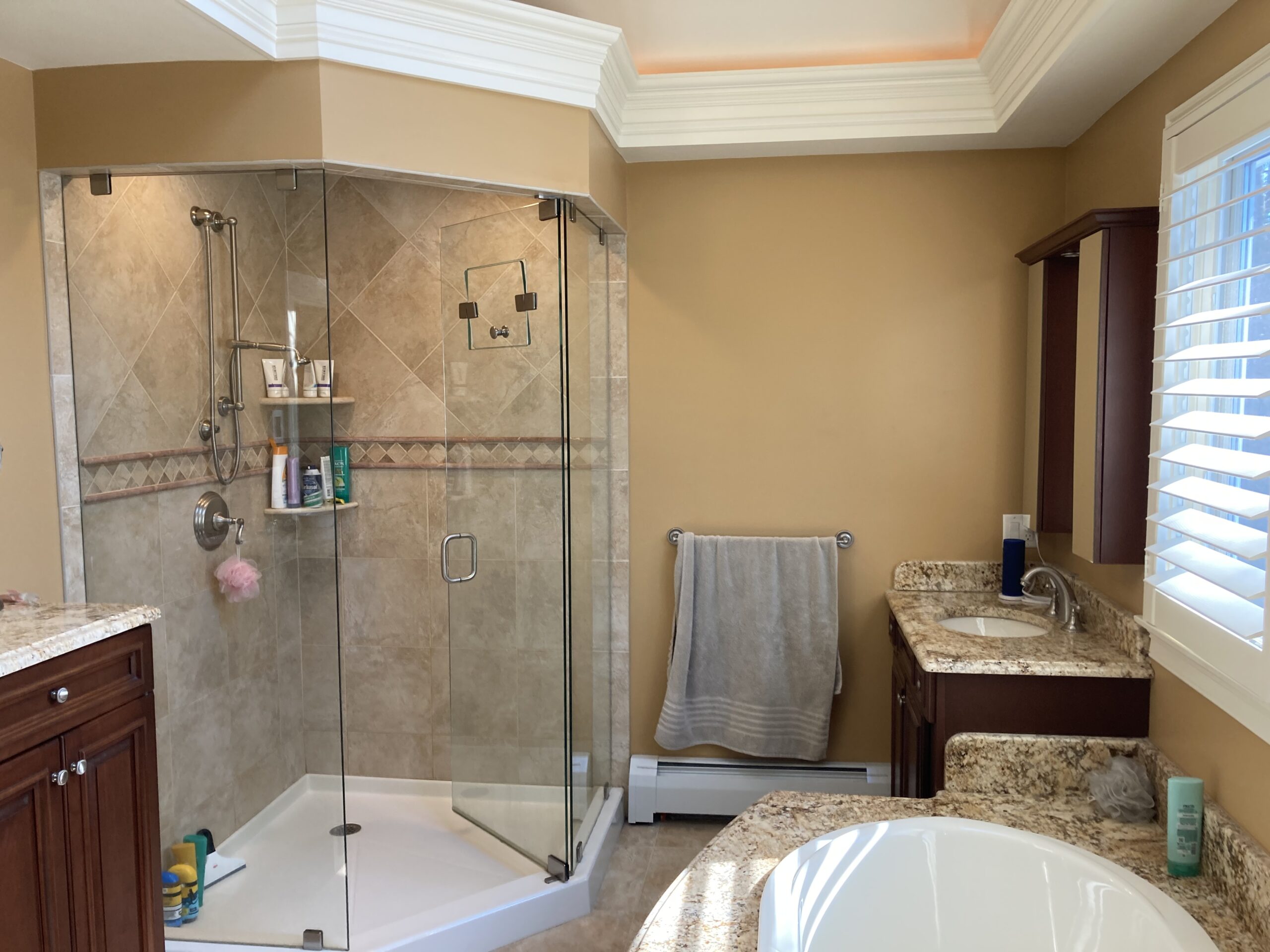 Tan-tiled standing shower with the door open