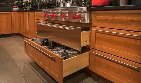 Kitchen with black-trimmed windows, black marbled backsplash, wooden cabinetry, and stainless steel accents