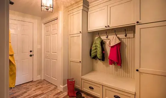 Powder room with vertical white-paneled wainscoting and vessel sink with rustic wooden base and black pipes/faucet