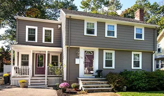 Grey house with large exterior back deck addition and string lights