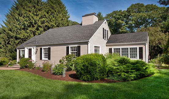 Kitchen with granite counters, white cabinets, and barstool chairs