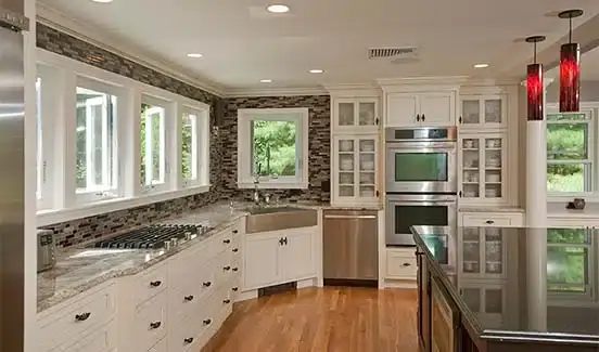 Kitchen upgrade with large black island, red light fixtures, and windows across backsplash wall