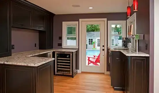 Kitchen upgrade with large black island, red light fixtures, and windows across backsplash wall