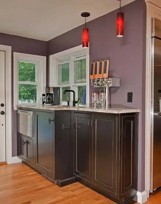 Kitchen upgrade with large black island, red light fixtures, and windows across backsplash wall