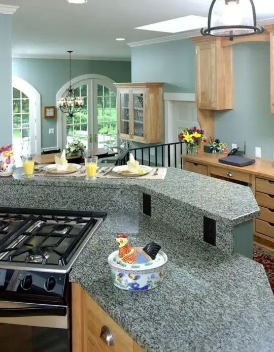 Two-tier kitchen island and light wooden cabinetry