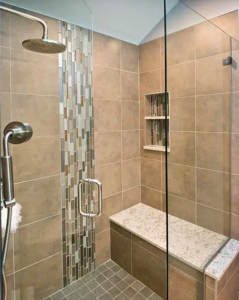 Blackdog Design/Build MA bathroom remodel with tan tile wall and bench in glass-enclosed shower with rain showerhead.