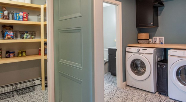 Well-organized small laundry room with shelving to the left.