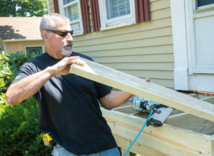 Home Services technician working with fresh lumbar outdoors for a home service project.